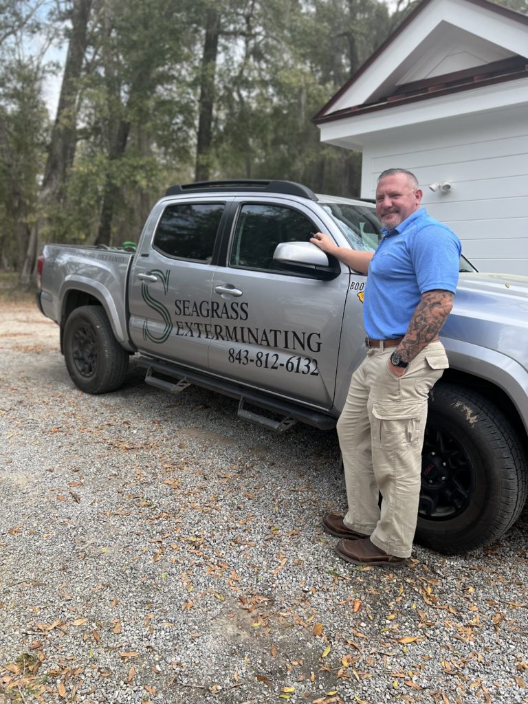 Seagrass Exterminating owner standing next to work truck